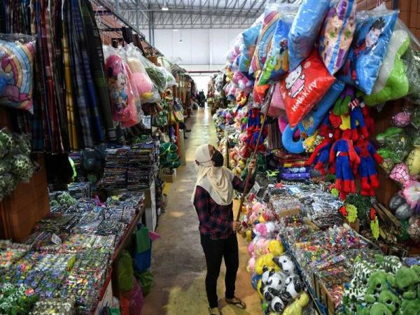 Peniaga menggantung barangan untuk dijual kepada pelanggan selepas kerajaan mengumumkan PKPP berkuatkuasa hari ini ketika tinjauan di Pasar Besar Kedai Payang hari ini. Foto Bernama