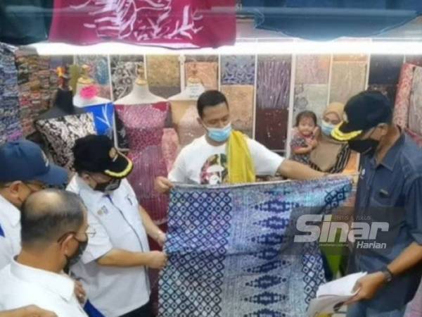 Alexander (tiga dari kiri) melihat produk yang dijual di Pasar Besar Kedai Payang.