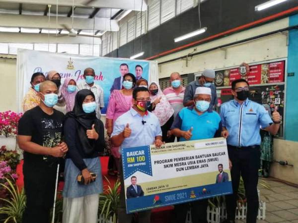 Amirudin (tengah) menyampaikan baucer Skim Mesra Usia Emas (SMUE) DUN Lembah Jaya di Laman Niaga@Ampang Waferfront, Ampang pada Sabtu.