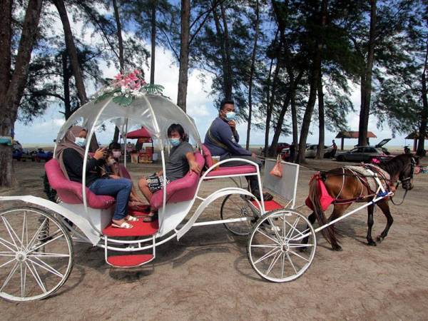 Pengunjung menaiki kereta kuda yang menjadi salah satu tarikan di Pantai Kempadang ketika tinjauan hari ini.