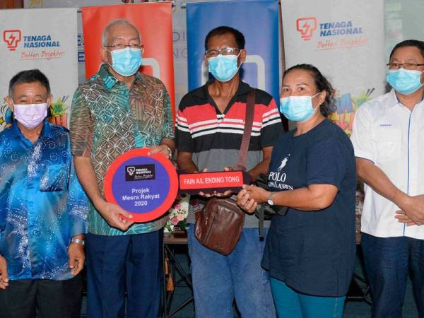 Mahdzir (dua, kiri) menyerahkan kunci rumah kepada Fain a/l Ending Tong, 56, dan isterinya Eekim a/p Inem, 50, pada Program CSR TNB Ceria ke Sekolah di Pejabat Pendidikan Daerah Padang Terap, Kuala Nerang hari ini. - Foto Bernama