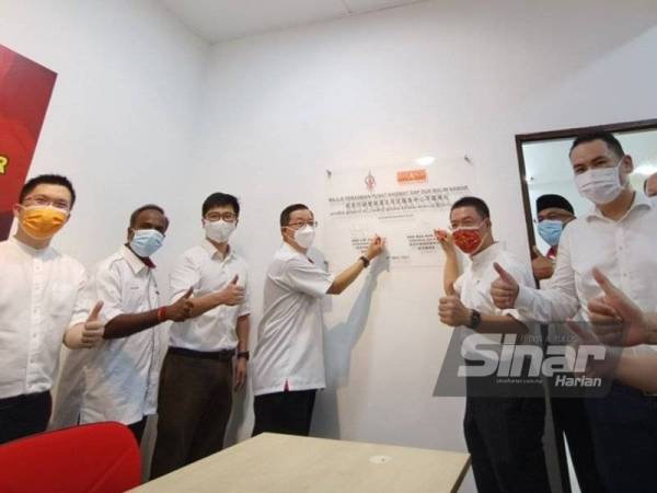 Guan Eng (kiri) bersama Pengerusi DAP Perak, Nga Kor Ming menurunkan tanda tangan sebagai gimik perasmian pembukaan Pusat Khidmat DAP DUN Malim Nawar di Taman Malim Nawar, Ipoh pada Ahad.