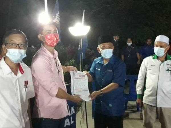 Tosrin (dua dari kanan) menerima 300 borang keahlian baharu Bersatu daripada masyarakat Cina di rumahnya di Felda Taib Andak, Kulai pada malam Sabtu.