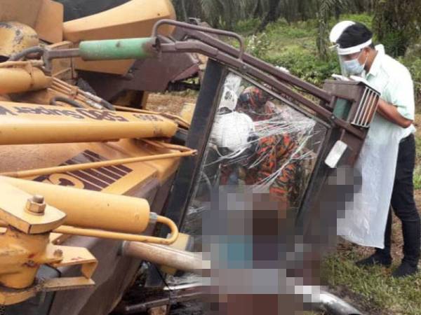 Anggota bomba membantu mengeluarkan pemandu jengkaut yang tersepit selepas jengkaut dipandunya terbalik Simpang Lima, Seri Sulong pada Ahad.- Foto Ihsan Bomba