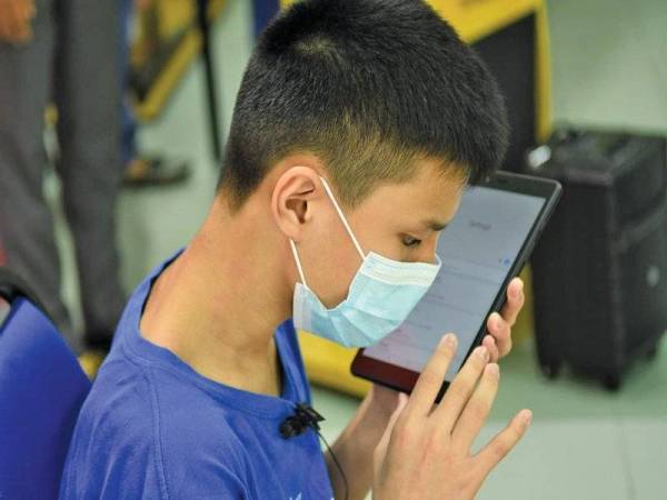 Meng Fatt memberi demonstrasi bagaimana aplikasi bantuan suara membantu dia belajar