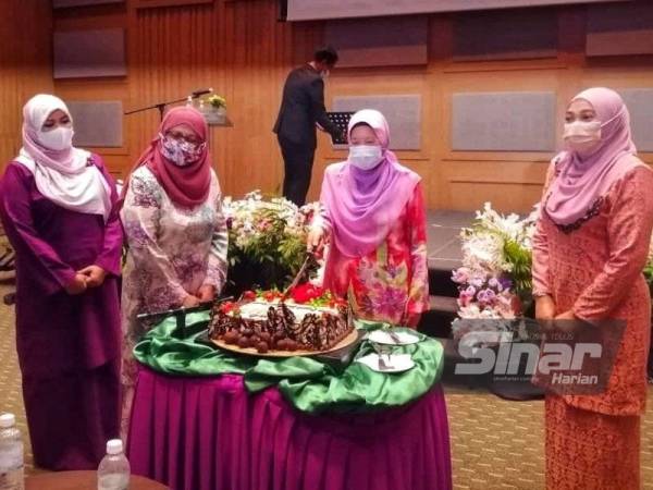 Azizah memotong kek sempena sambutan Hari Wanita peringkat Mara di Kuala Lumpur pada Isnin.