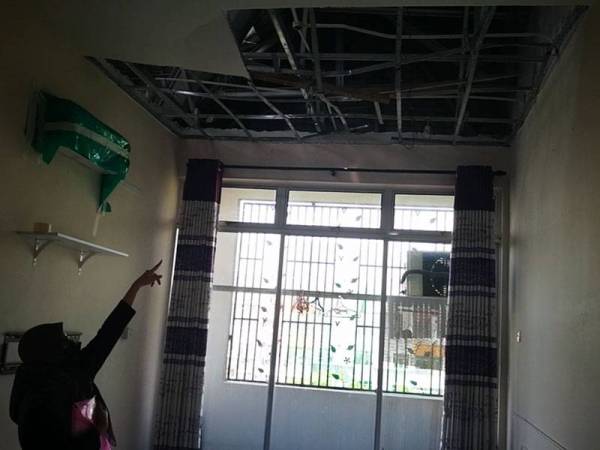 Nur Farah menunjukkan keadaan siling di ruang tamu pangsapuri didiaminya di Apartment Dahlia Court, Bandar Baru Salak Tinggi, Sepang.