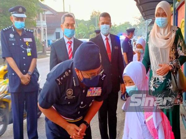 Shafien bertanya khabar seorang murid semasa turun padang meninjau pematuhan SOP di SK Mulong 2, Kota Bharu pada Selasa.