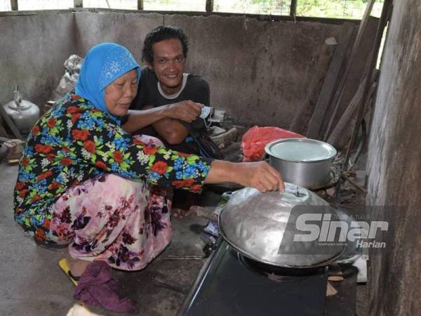 Sufian membantu ibu saudaranya memasak di dapur rumahnya di Kampung Parit Permatang, Senggarang, Batu Pahat pada Selasa.