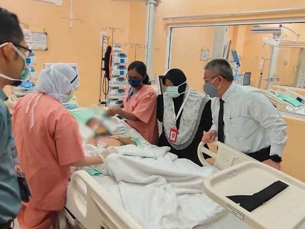 Dr Adham (kanan) ketika menziarahi Ra'if Adam di Hospital Tuanku Azizah Kuala Lumpur hari ini. - Foto: Facebook Dr Adham Baba