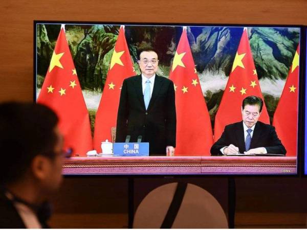 Perdana Menteri China, Li Keqiang menyaksikan Menteri Perdagangan China, Zhong Shan menandatangani perjanjian Perkongsian Ekonomi Komprehensif Serantau (RCEP) pada sidang kemuncak ASEAN dalam talian pada 15 November lalu. - Foto AFP