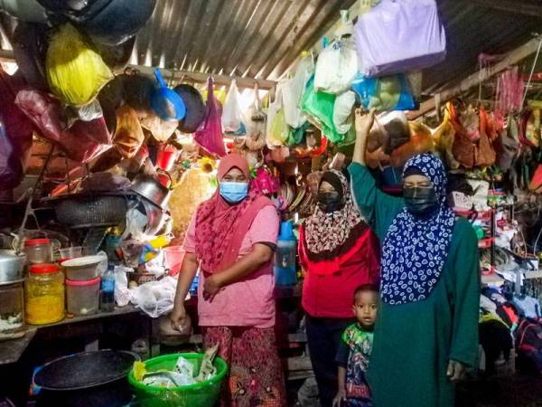 Rokiah bersama anak-anak menunjukkan keadaan dapur rumah mereka yang usang dan dipenuhi plastik di Kampung Padang Bemban. - Foto Bernama