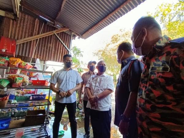 Saarani (tiga dari kiri) meluangkan masa meninjau lokasi kebakaran yang memusnahkan lima deretan kedai di Kampung Simpang 3, Kuala Kurau pada Selasa.