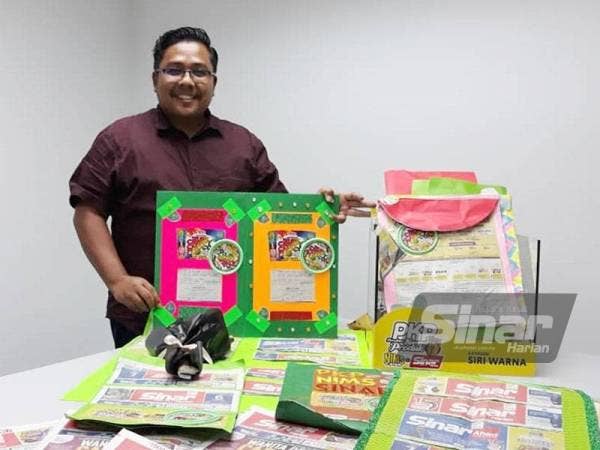Zamri menunjukkan hasil gabungan penutup Crispy Choco Tub dan keratan kepala akhbar Sinar Harian yang telah dihantar oleh peserta Peraduan PKPNimsXSinar.