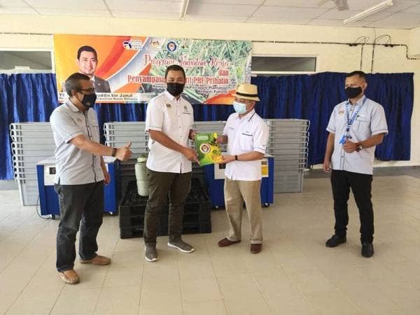 Sahruddin (dua dari kiri) menyampaikan Insentif Pre Prihatin Pengusaha Nanas kepada pihak Rompin Integrated Pineapple Industries Sdn Bhd (RIPI) yang diwakili Mohd Hiswandi (dua dari kanan) sempena lawatan kerja beliau ke RIPP, Kampung Tanam, Kuala Rompin, Rompin pada Selasa.