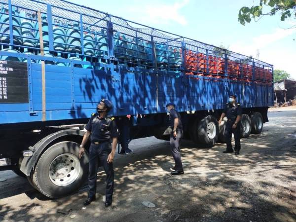 Pegawai KPDNHEP Cawangan Taiping memeriksa treler yang membawa tong gas petroleum cecair yang diparkir di sebuah premis di Simpang, Taiping dalam satu operasi pada Selasa.