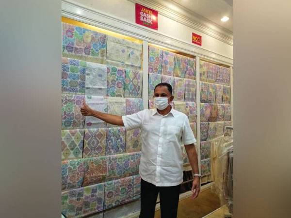 Mohamed Faroz menunjukkan koleksi kain sampin keluaran Jakel.
