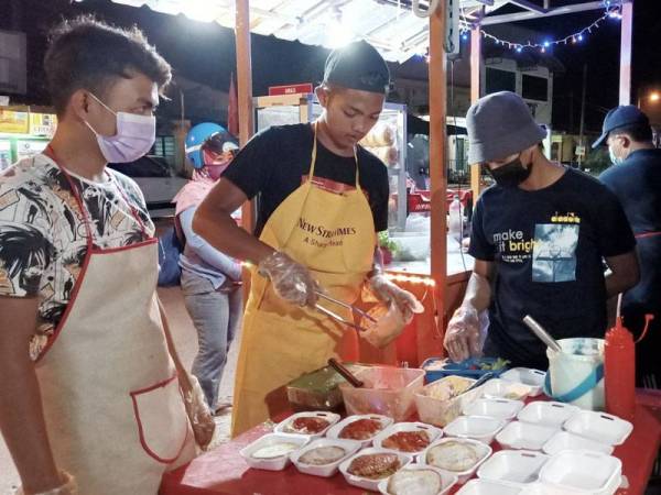 Wan Muhammad Iqbal meminta bantuan rakan-rakan untuk menyiapkan 100 burger percuma.