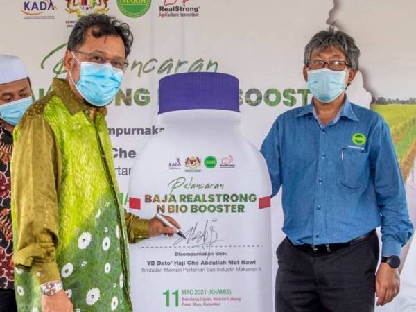 Che Abdullah ( kiri) ketika perasmian pelancaran Baja Realstrong N Bio Booster di Bendang Lipan, Mukim Lalang hari pada Khamis.