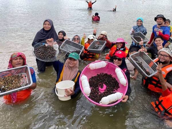 Sebahagian peserta aktiviti mencari etok anjuran urusetia Kalang Warisan bersama hasil yang diperoleh ketika air pasang surut di Sungai Terengganu.
