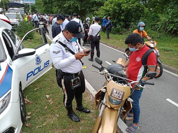 Polis memeriksa penunggang motosikal dalam Ops Bersepadu Khas Ekzos Bising di Kilometer 29.3 Lebuhraya Persekutuan pada Jumaat.