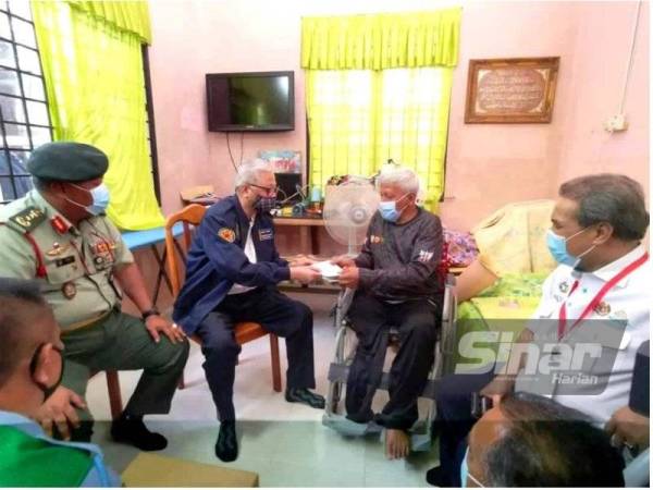 Ismail Sabri (dua dari kiri) menyampaikan sumbangan kepada Md Salleh ketika melawat kediamannya sempena program Cakna Veteran ATM di Pantai Johor, Alor Setar pada Jumaat.