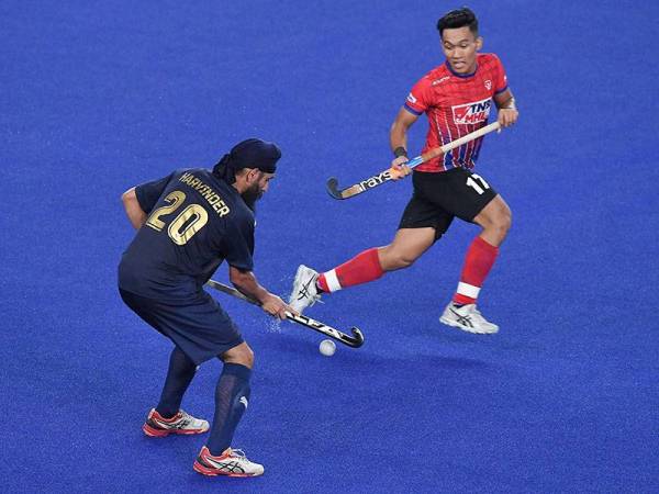 Pemain UniKL Harvinder Singh (kiri) mengawal bola sambil cuba dicabar oleh pemain TNB Razie Abd Rahim pada perlawanan Piala Sumbangsih TNB Liga Hoki Kebangsaan 2021 di Stadium Hoki Bukit Jalil malam ini.