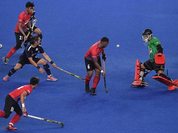 Penjaga gol TNB Mohammad Hairi Abd Rahman (kanan) menghalang percubaan pemain TNB pada perlawanan Piala Sumbangsih TNB Liga Hoki Kebangsaan 2021 di Stadium Hoki Bukit Jalil malam ini.