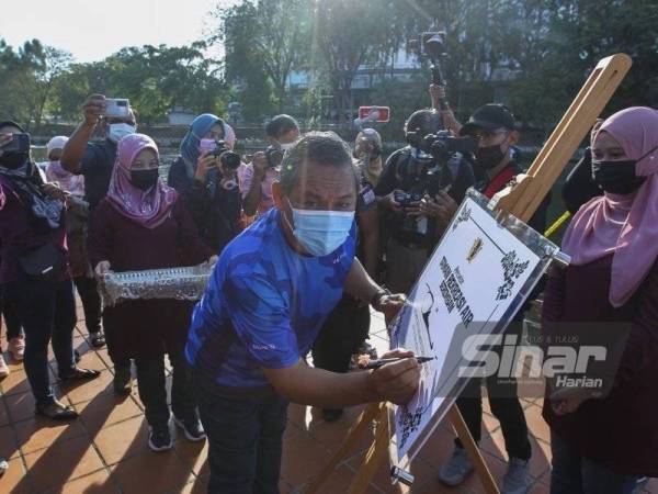 Aminuddin menandatangani plak perasmian Taman Rekreasi Air Seremban.