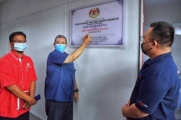 Saifuddin Abdullah (tengah) menurunkan tandatangannya pada simbolik perasmian Pusat Khidmat Parlimen Indera Mahkota Cawangan Semambu,hari ini. -Foto Bernama
