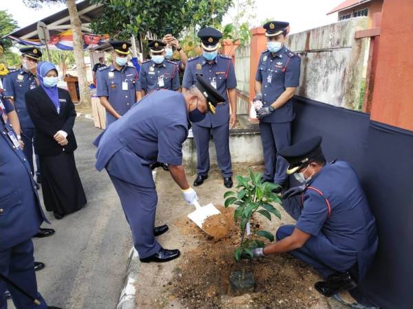 Datuk Soiman (kiri) menanam pokok cempedak durian di pekarangan bangunan ibu pejabat JBPM Terengganu sebagai tanda ingatan sempena Lawatan Kerja Rasmi ke JBPM Terengganu pada Ahad.