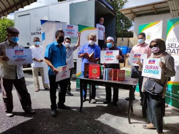 Ariffin (tiga dari kanan) melihat naskhah al-Quran yang disumbangkan Yayasan Warisan Ummah Ikhlas kepada penerima terpilih. Penyerahan dilakukan Sekretariat Yayasan Warisan Ummah Ikhlas, Hashim Anang (tiga dari kiri).