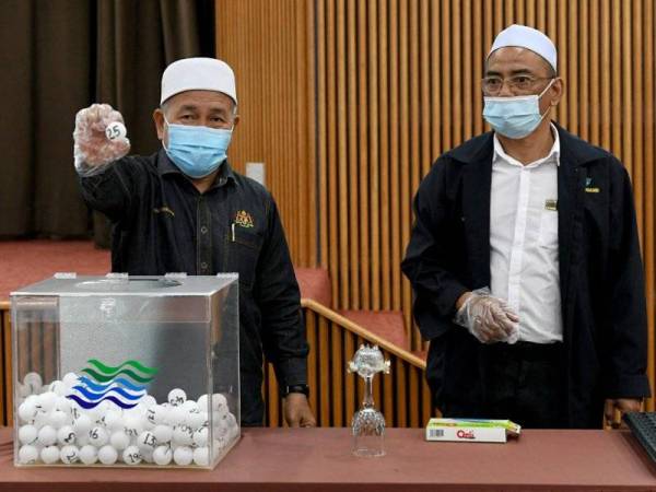 Tuan Ibrahim (kiri) menunjukkan undi yang dicabut pada Majlis Cabutan Kerja Undi di bawah peruntukan KASA di Wisma Darul Iman, pada Ahad.