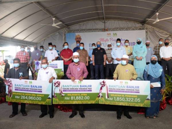 Ronald (tengah) bersama wakil penerima Tabung Bencana Tanaman Padi bagi September dan Oktober tahun lepas di (PPK H-II, Jitra pada Isnin.