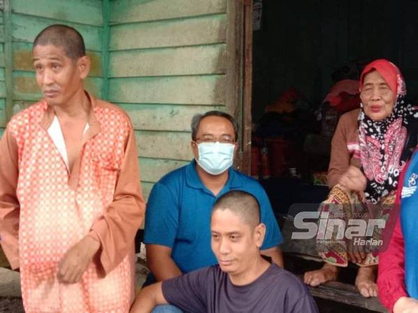 Mohd Fadel (dua dari kiri) melawat Norhadiah dan dua anaknya yang memerlukan bantuan di Kampung Paya, Simpang Renggam, Kluang pada Rabu.