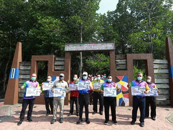 Shamsul Anuar (tengah) terlibat menanam pokok bakau di Taman Paya Bakau Bandar, Lumut.