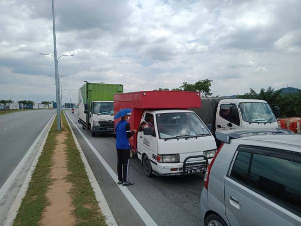 Antara aktiviti peniaga persimpangan lampu isyarat di Jalan Mokhtar Dahari, Puncak Alam.