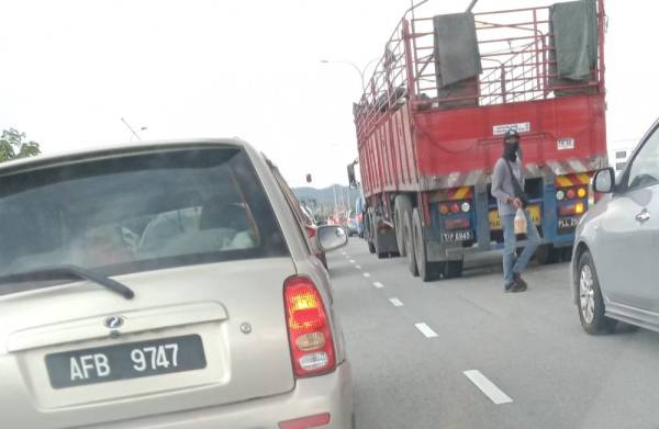 Penjaja akan bergerak dari satu kenderaan ke satu kenderaan lain ketika lampu isyarat bertukar merah.
