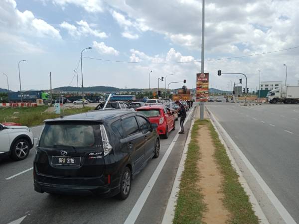 
Seorang penjaja singgah dari satu kenderaan ke satu kenderaan untuk menjual jeruk buah di Puncak Alam.