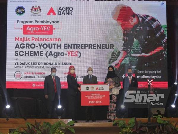 Ketua Setiausaha MAFI, Datuk Haslina Abdul Hamid (dua dari kanan menyampaikan replika cek kepada Penanggung Tugas Presiden/Ketua Pegawai Eksekutif Agrobank, Khadijah Iskandar sambil diperhatikan oleh Kiandee di Majlis Pelancaran Agro-YES di Putrajaya.