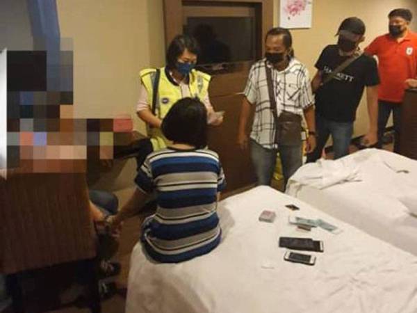 Pegawai dan anggota menjalankan pemeriksaan terhadap kedua-dua suspek selepas didapati menjalankan aktiviti persundalan di sebuah hotel di Jalan Sulaman, Kota Kinabalu.
