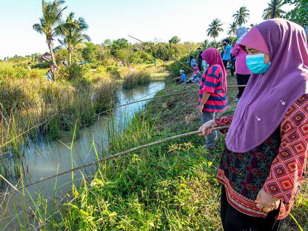 Salah seorang peserta yang mengambil bahagian pada pertandingan memancing secara tradisional di tali air sawah Kampung Bukit Kechik, Melor di sini.