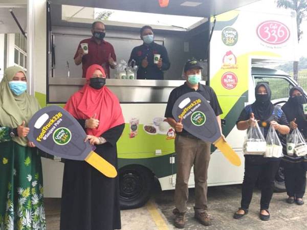 Hasnol Zam Zam (atas dari kiri) pada penyerahan kunci kepada usahawan 'Food truck' pada Majlis Pelancaran Outlet Drive Thru Coconut Shake 336 di Bestari Jaya di sini pada Sabtu.