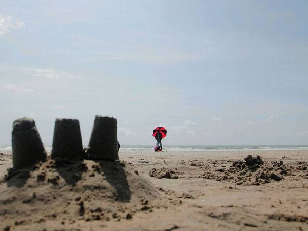 Pengunjung berpayung berikutan cuaca panas berkelah di Pantai Kempadang hari ini.