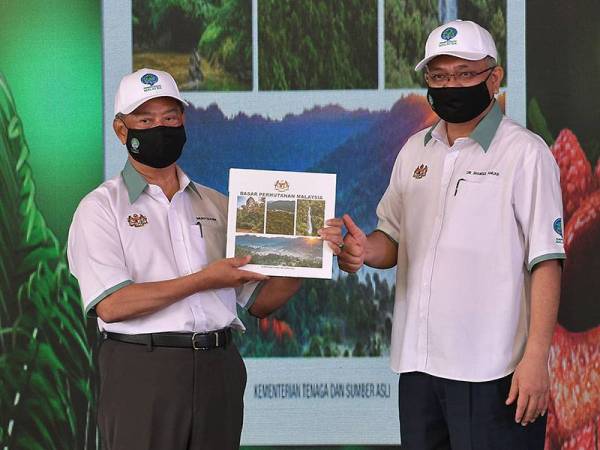 Perdana Menteri Tan Sri Muhyiddin Yassin menunjukkan buku Dasar Perhutanan Negara pada Majlis Pelancaran Dasar Perhutanan Malaysia sempena Sambutan Hari Hutan Antarabangsa peringkat kebangsaan tahun 2021 di Taman Botani Kepong, Institut Penyelidikan Perhutanan Malaysia (FRIM) hari ini.