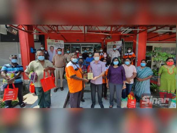 Antara ahli Persatuan Pengusaha Bas Sekolah Seremban yang menerima sumbangan makanan daripada Ahli Parlimen Rasah, Cha Kee Chin (tengah) di Pejabat Ahli Parlimen Rasah pada Ahad.