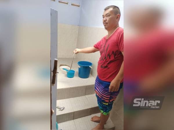 Yusri menunjukkan tandas rumahnya yang tidak dapat digunakan dengan sempurna ekoran ketiadaan bekalan air.