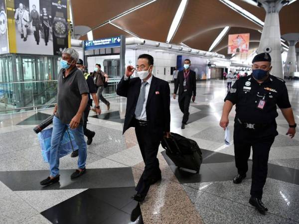 Kuasa Usaha Kedutaan Korea Utara, Kim Yu-Song diiringi pihak polis sebelum menaiki pesawat komersial syarikat Shanghai Airlines penerbangan FM886 ke Pudong, China. - Foto Bernama