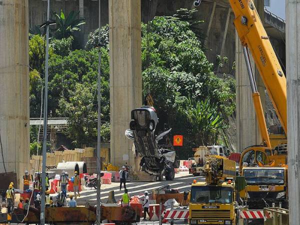 Kerja-kerja pengalihan kenderaan yang remuk selepas dihempap struktur besi kren yang jatuh di tapak pembinaan Lebuhraya Bertingkat Sungai Besi-Ulu Kelang (SUKE) di Alam Damai, pagi Isnin.
Foto Bernama