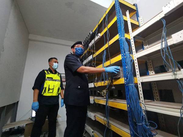 Mohd Fazley menunjukkan mesin bitcoin yang ditemui di sebuah premis.